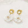 Boucles d'oreilles dorées avec fleurs blanches pendantes