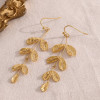 Boucles d'oreilles pendantes dorées branche avec feuilles rondes brossées