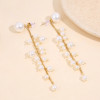 Boucles d'oreilles pendantes dorées ornées de perles à l'arrière