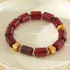 Bracelet élastique résine cylindrique rouge ambré anneaux séparateurs dorés